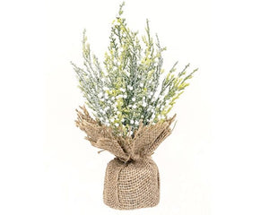 Faux plant in a burlap sack on a white background