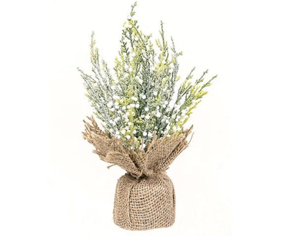 Faux plant in a burlap sack on a white background