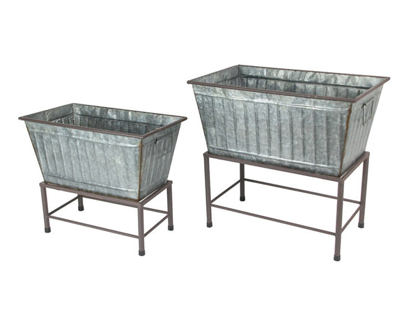 Two metal planters on stands against a white background
