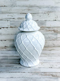 White ceramic jar with lid on a wooden surface