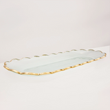 Rectangular oval glass tray with scalloped edge and gold trim on a white background