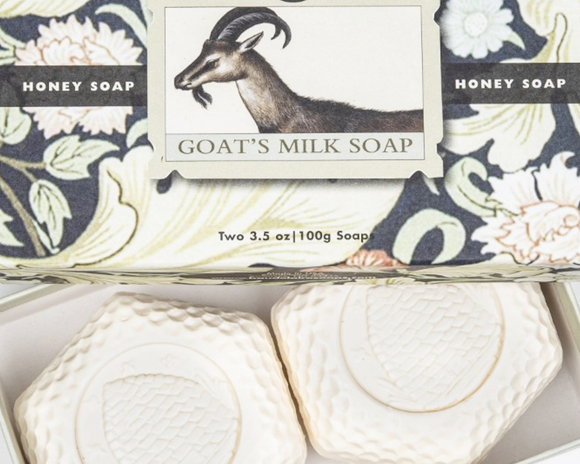 Two goat's milk soaps in a box with packaging featuring a goat illustration.