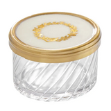 Store small bath essentials or jewelry in this gorgeous lidded jar. It features a gold-color wreath along the top of the lid with a matching rim. The glass is cut to give it a multidimensional feel. This really is a pretty piece!  Materials: Glass, brass  Dimensions: 2 1/2" high x 3 1/2" round