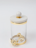 Decorative glass jar with marble lid and gold accents on a white background