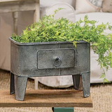 Whether used to display your favorite artificial plant or to hold small household items, this metal basin coordinates well with almost all styles of decor, including classic country and rustic farmhouse. It features a distressed gray finish and has a decorative drawer along the front for added character. This is a charming piece that is sure to please just about everyone.