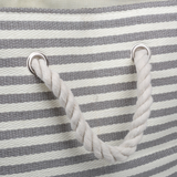 Close-up of a striped bag with rope handles on a gray and white background