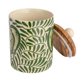 This round stoneware canister with a botanical design and acacia wood lid is a delightful addition to any countertop. Its round shape and natural green palette evoke a sense of calm, reminiscent of a garden in bloom. The acacia wood lid fits snugly, preserving the contents while adding a touch of rustic elegance. Whether used for storing tea, coffee, or sweet treats, or simply as an accent piece, this canister is a functional yet decorative element that complements farmhouse, Scandinavian, or rustic decor w
