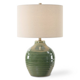 Green ceramic table lamp with a beige lampshade on a white background