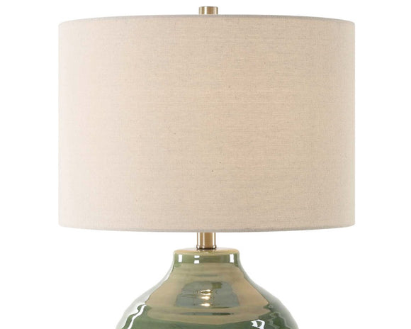 Table lamp with a beige shade and green base on a white background