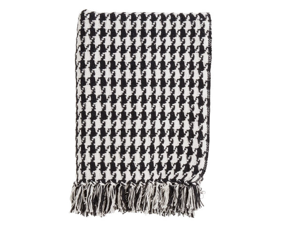 Black and white houndstooth patterned throw blanket with fringes on a white background