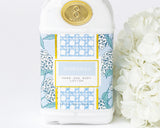 Hand and body lotion bottle with floral design and gold label on a white background