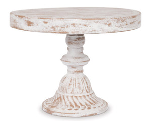 Round wooden cake stand with a white distressed finish on a white background