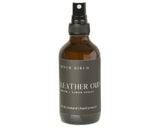 Brown leather spray bottle with black label on a white background