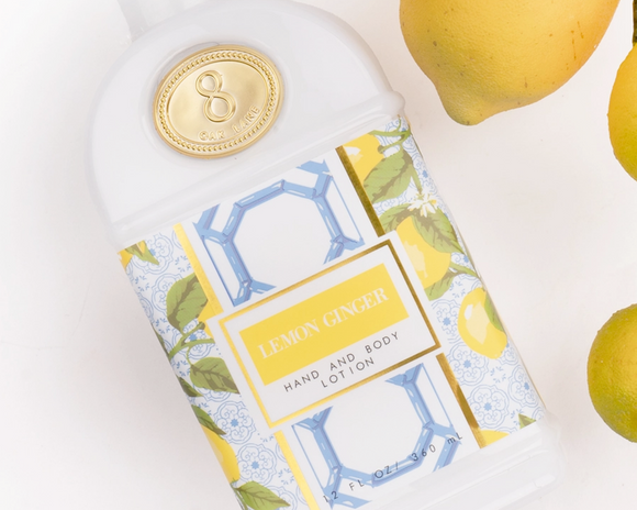 Hand and body lotion bottle with lemon ginger flavor, surrounded by lemons on a light background