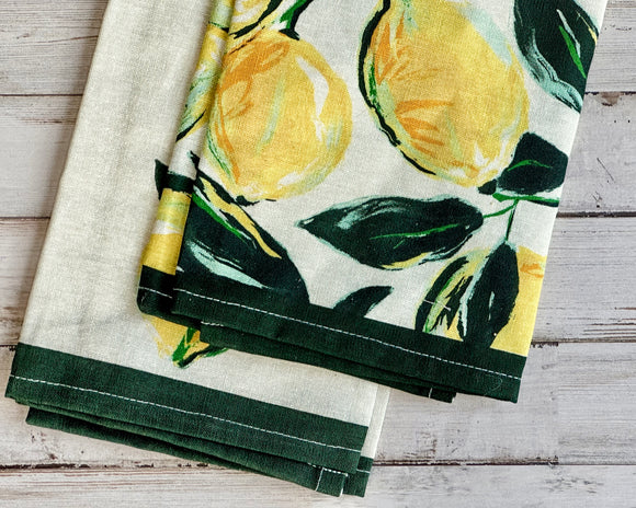Set of tea towels with lemon design on a wooden surface