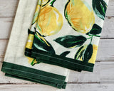 Set of tea towels with lemon design on a wooden surface