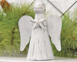 White angel figurine with a star on its chest against a green foliage background