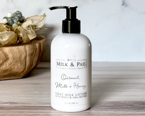 Milk & Pail lotion bottle on a wooden surface with decorative elements.