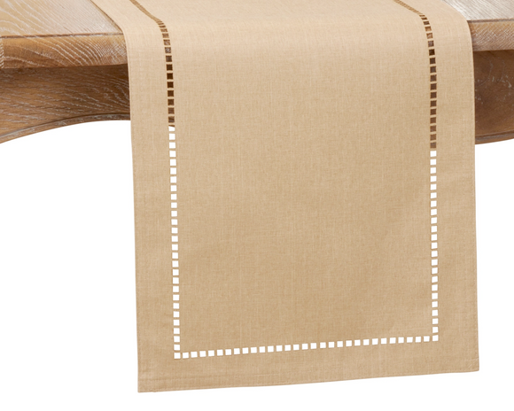 Beige table runner with white hemstitching on a wooden table
