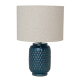 Table lamp with textured navy base and beige lampshade on a white background