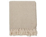 Neutral beige throw blanket with thick decorative tassel details displayed on a clean white background.