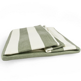 Folded green and white striped towel on a white background