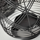 Close-up of a black wire basket on a light background