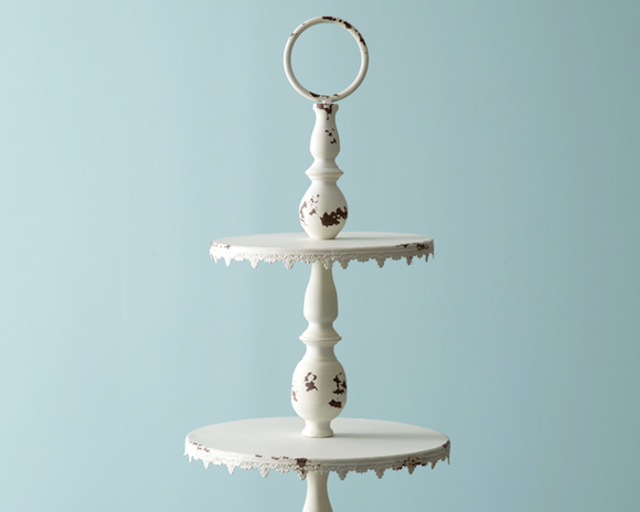 Ornate distressed creamy white tiered tray

Display desserts for a wedding or small items for your store on this feminine display stand. It features a loop to carry and is a large piece measuring almost 3 feet tall. It is made of metal and not food safe. It is recommended to use with dollies or liners.

Materials:
Metal

Dimensions:
14