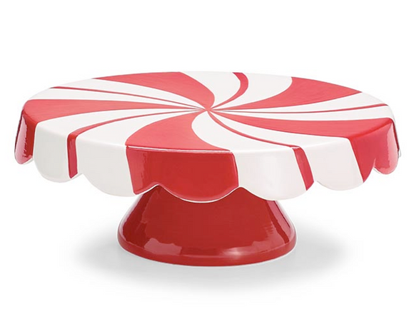 Red and white cake stand with a peppermint swirl pattern on a white background