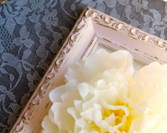 Decorative white flower with a decorative frame on a lace background