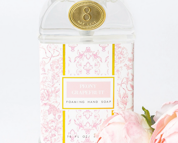 Foaming hand soap bottle with floral design and peony grapefruit label on a white background