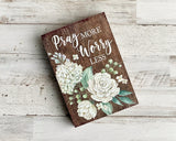 Wooden 'Pray More, Worry Less' shelf sitter

Add this lovely sign to a bookcase or desk for a daily inspirational reminder to trust in the Lord. The plaque reads, "Pray More, Worry Less," atop a dark brown wooden background. It is flanked by ivory blooms along the side. This piece also makes for a great gift.

Materials:
Wood

Dimensions:
5" wide x 1" deep x 7" long
