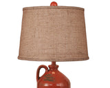 Lamp with a brown lampshade and red ceramic base on a white background