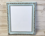 Decorative picture frame with ornate design on a wooden background