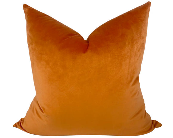 Orange velvet pillow on a white background