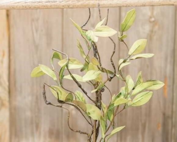 Artificial plant with green leaves against a wooden background