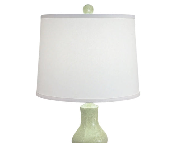 Table lamp with a white shade and green base on a white background