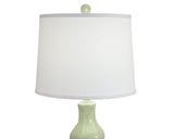 Table lamp with a white shade and green base on a white background