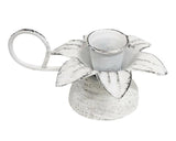 This small metal taper candle holder features a brushed white antique finish. The holder has a flower design with petals blooming out of the middle and contains a curved handle attached to the side of the piece. This is a great piece for spring or year-round use.<br>