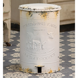 Vintage-style metal produce trash bin with 'Southwind Farm' branding on a patterned rug.