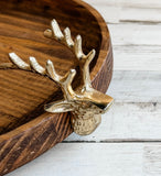Wooden tray with a gold deer head and antlers on a wooden surface