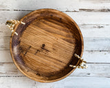 Wooden bowl with gold handles on a rustic wooden surface