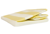 Yellow and white striped beach towel on a white background