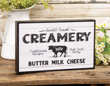 'Sweet Creek Creamery' wooden box sign

Our box sign offers a classic farmhouse look with black and white artwork in the style of an antique creamery advertising sign. This eye-catching piece features painted black side panels which frame the vintage influenced design. This sign makes for a great addition to your kitchen.

Materials:
Wood

Dimensions:
7 1/2" high x 1 1/2" deep x 11 3/4" wide