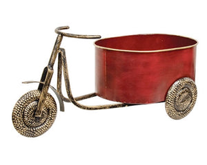 Decorative planter shaped like a red bicycle with gold accents on a white background