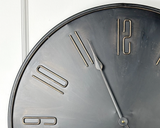 This round industrial style metal clock makes a great accent for any room. It features a dark black with a bronze highlighted finish with easy-to-read antique gold number accents and very light gold brush marks. It features Youngstown quartz movement. It is a beautiful focal point and will complement almost any decor.&nbsp;