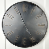 This round industrial style metal clock makes a great accent for any room. It features a dark black with a bronze highlighted finish with easy-to-read antique gold number accents and very light gold brush marks. It features Youngstown quartz movement. It is a beautiful focal point and will complement almost any decor.&nbsp;