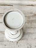 White &amp; gray short pillar candle holder
*Made to order*

If you’re looking for farmhouse dining table decorations or shelf decor, look no further! These wooden candle holders complement almost any home or dining room decor. Place several of these candlesticks in a group on a dining room table for centerpiece or on a mantel in a living room for a vintage-inspired spring candlescape.

Sold individually, each candle holder is painted in white and accented with a hand-rubbed black antiquing glaze to bring o