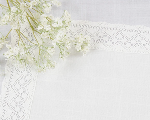 White flowers with lace ribbon placemat on a white background