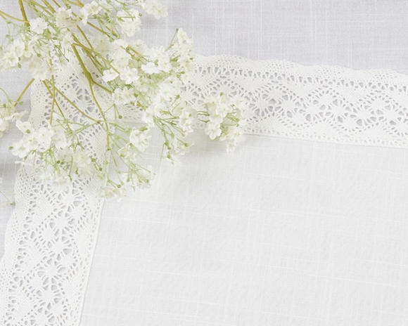 White flowers with lace ribbon placemat on a white background